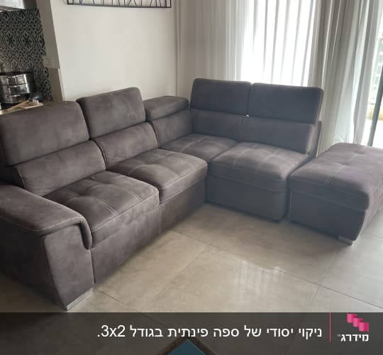 ספה אפורה בסלון עם אור טבעי
